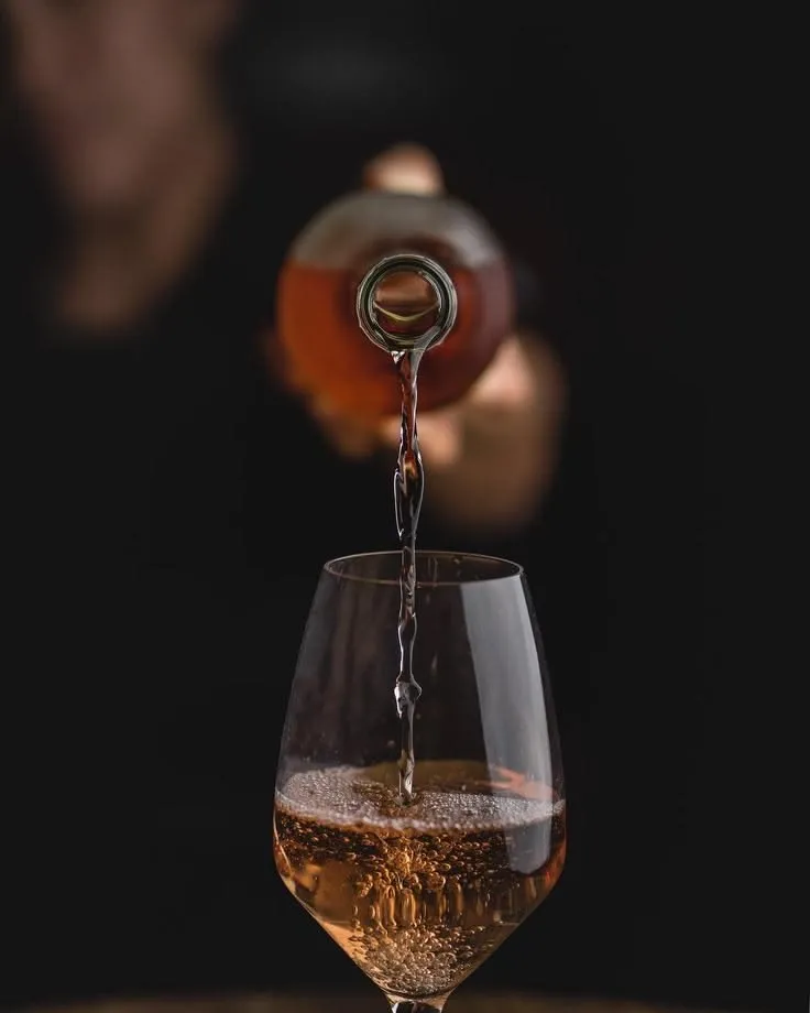 Wein wird bei dunkler, edler Stimmung ins Glas eingeschenkt