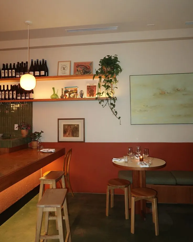 Kleine helle Weinbar mit Bordeaux-Sockel und Flaschenregal